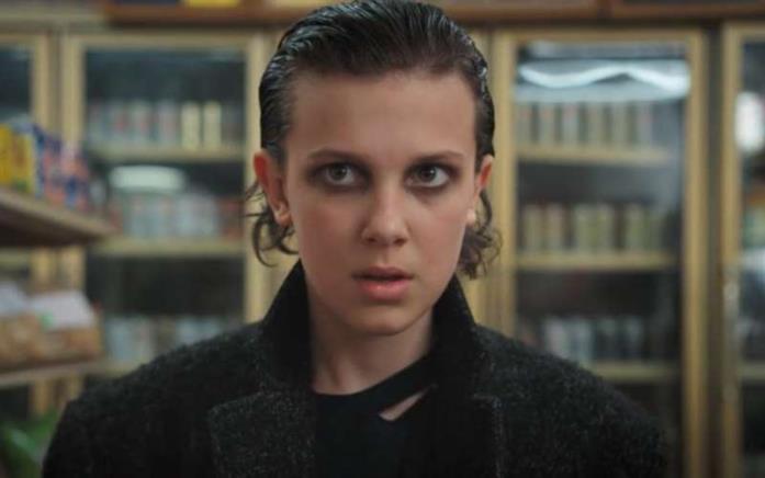 Millie Bobby Brown in Stranger Things Eleven si trova all'interno di un negozio