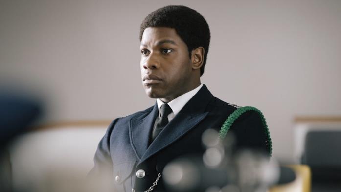 John Boyega nei panni di Leroy Logan Leroy Logan è seduto in una stanza, mentre attende qualcosa