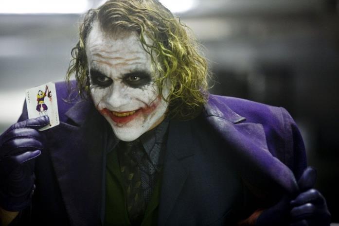 L'immenso Joker interpretato dal compianto Heath Ledger Mezzobusto di Heat Ledger truccato da Joker con una carta da gioco in mano