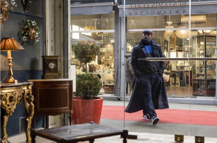 Omar Sy è Arsene Lupen mentre cammina davanti a un negozio