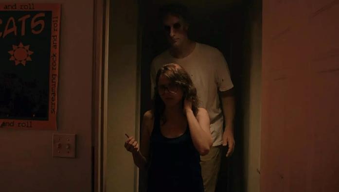 It Follows, di David Robert Mitchell (2014) Un ragazzo dagli occhi vuoti e molto inquietante incombe su Maika Monroe, di spalle