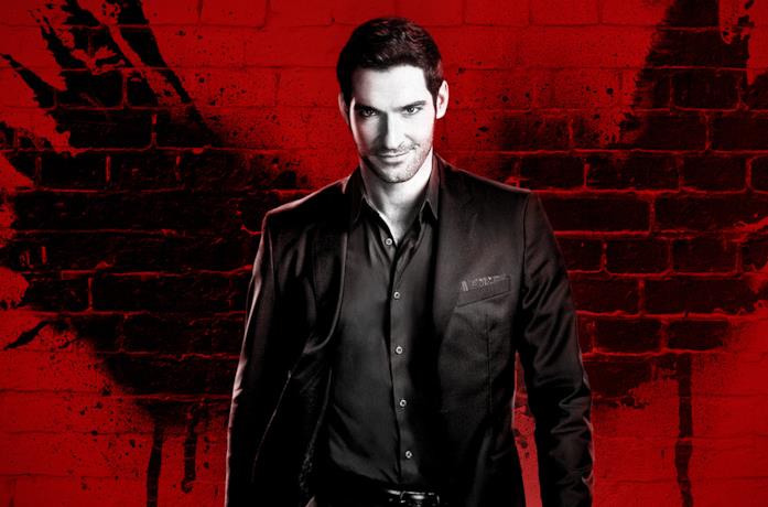 Lucifer Morningstar, con alle spalle un muro rosso, sorride