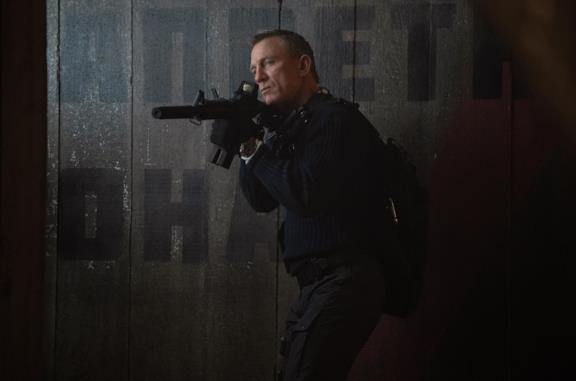 Daniel Craig con un fucile d'assalto