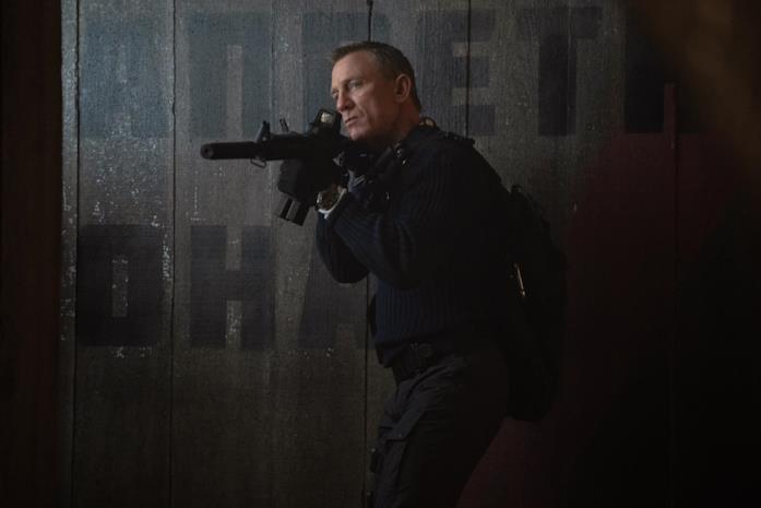Daniel Craig con un fucile d'assalto