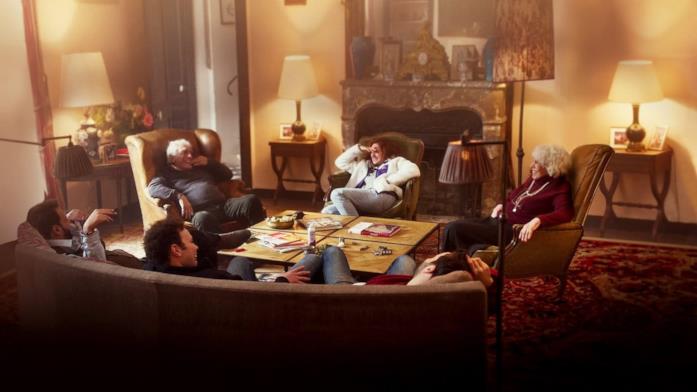 Una scena tratta dalla serie TV Altro che Caffè I gestori del coffee shop sono seduti intorno a un tavolo