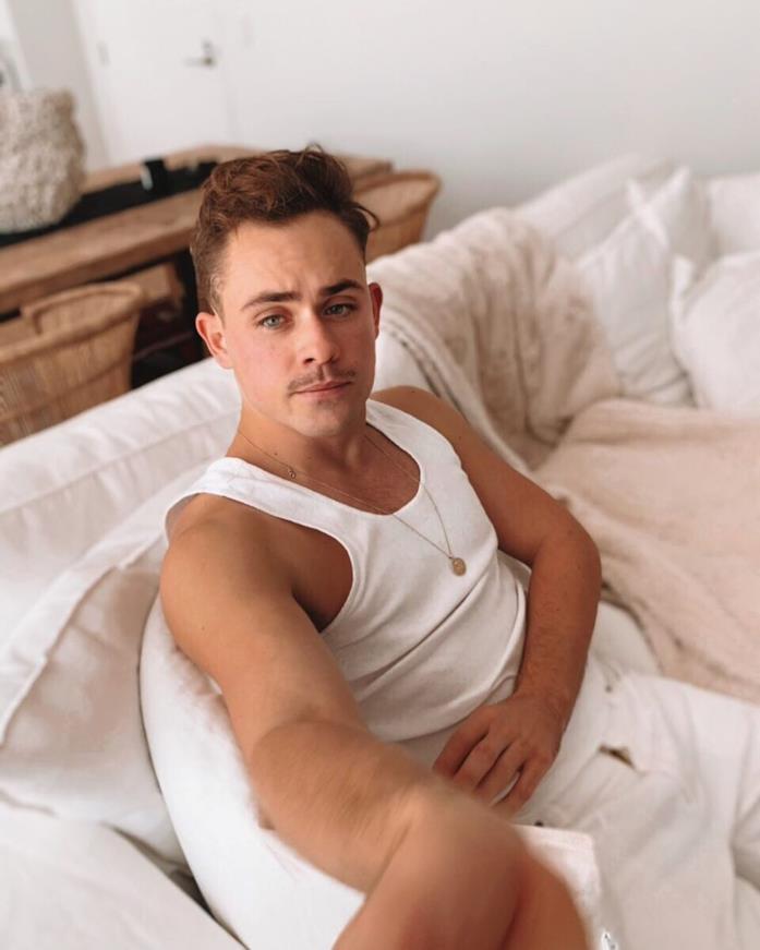 Dacre Montgomery in una foto recente, del 2019 Dacre Montgomery in canottiera e pantaloni bianchi, seduto su un sofà