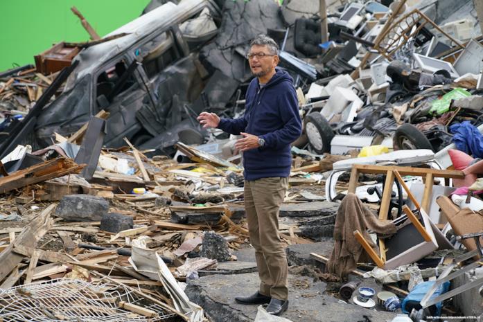 Hideaki Anno sul set di Shin Godzilla Il regista Hideaki Anno tra le macerie lasciate da Shin Godzilla