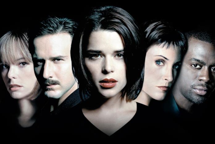 Neve Campbell al centro e gli altri protagonisti della saga di Scream vicino a lei