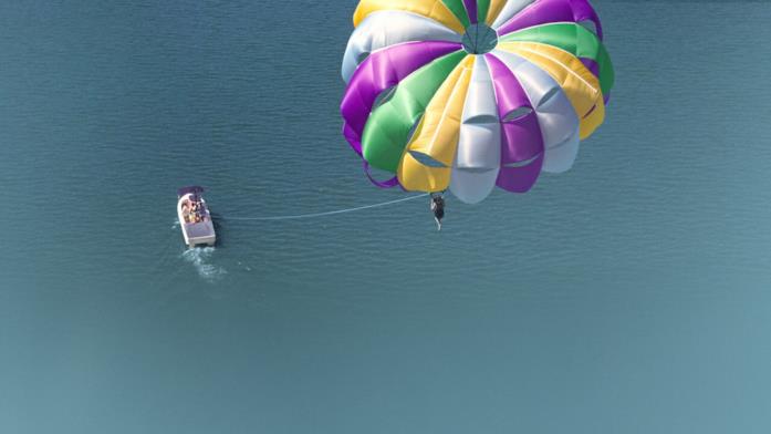 Parasailing in Che fine ha fatto Sara? Una scena di parasailing inquadrata dall'alto, su un mare limpido.