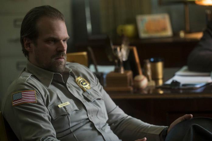 Lo sceriffo Hopper nella prima stagione di Stranger Things Jim Hopper seduto col cappello in mano in Stranger Things 1