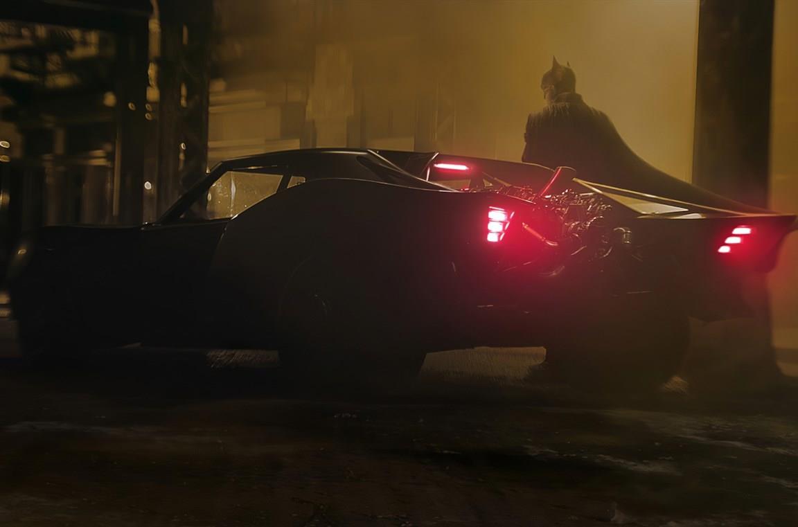Un'immagine di Batman al fianco della Batmobile