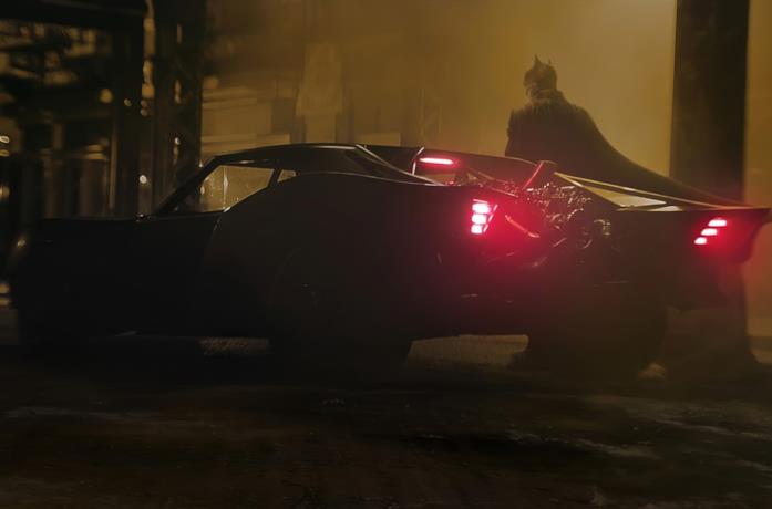 Un'immagine di Batman al fianco della Batmobile