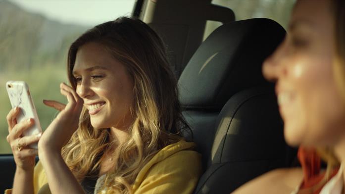 Elizabeth Olsen è Taylor Sloane Elizabeth Olsen guarda uno smartphone