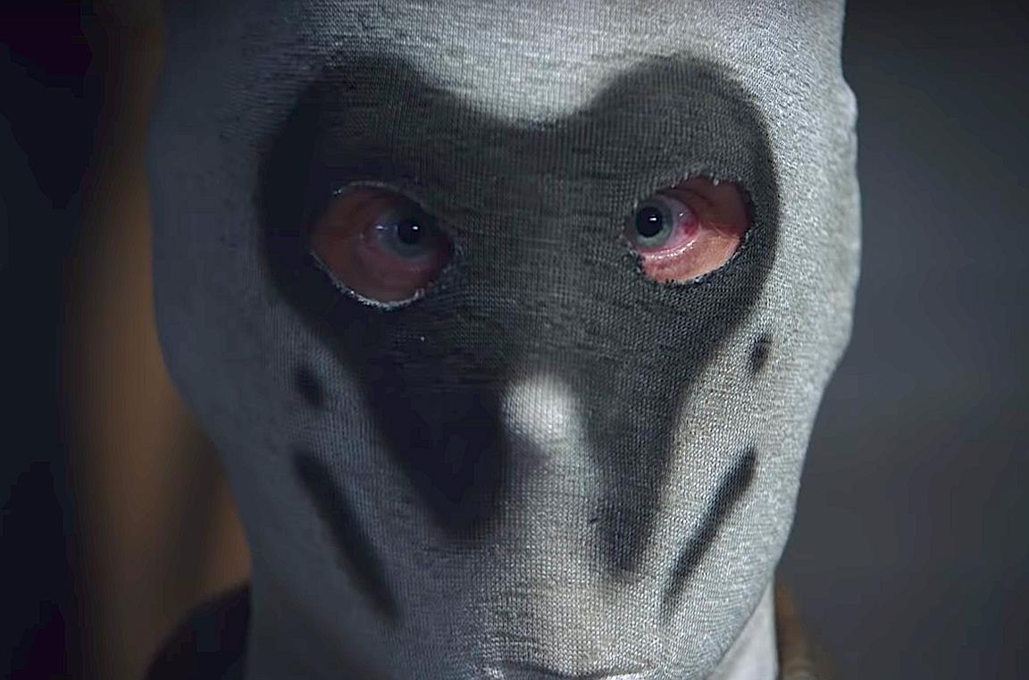 Un primo piano di un uomo con la maschera di Rorschach nella serie Watchmen