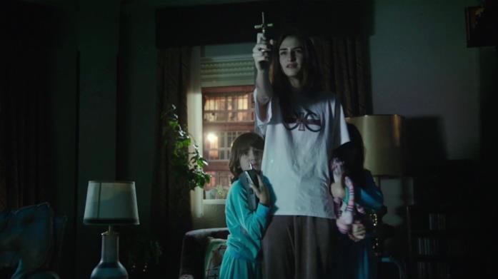 Veronica con le sorelline Veronica tende un crocifisso verso un demone per tentare di proteggere sé e i propri fratellini
