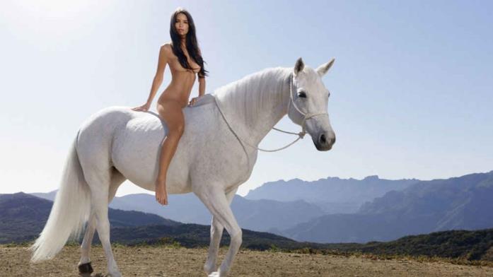 Emily Ratajkowski posa nuda a cavallo