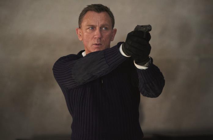 Primo piano di Daniel Craig che impugna una pistola