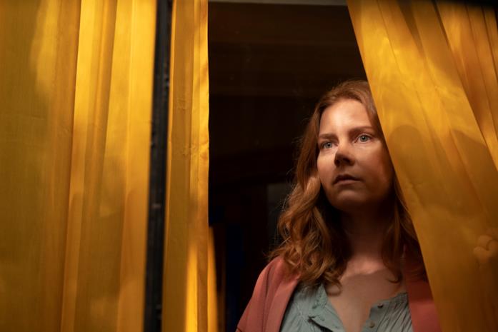 La donna alla finestra Amy Adams nei panni di Anna scosta una tenda