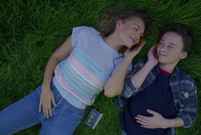 Meredith Quill e il giovane figlio Peter distesi sul prato ad ascoltare musica