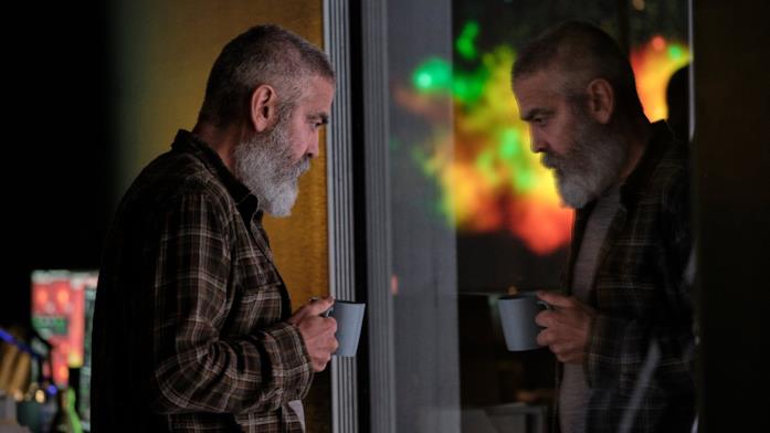 George Clooney alle prese con una catastrofe globale Mezza figura di George Clooney allo specchio con tazza in mano in una scena di The Midnight Sky
