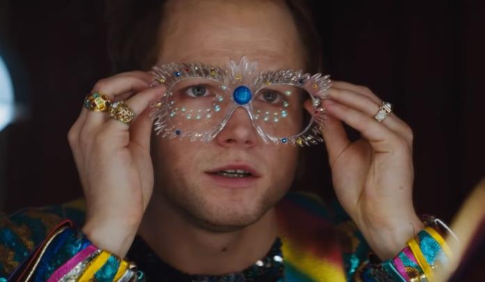Taron Egerton è Elton John nel film Rocketman Elton John indossa gli occhiali e si prepara a iniziare un'esibizione