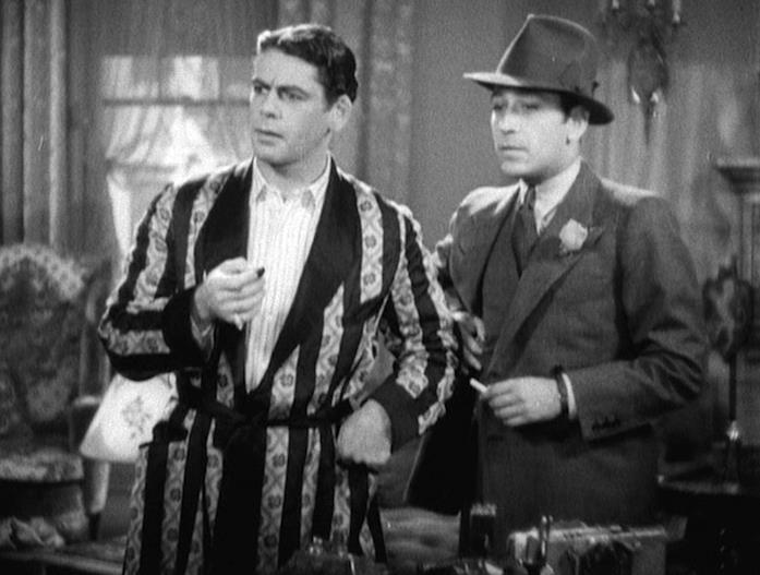 Paul Muni e George Raft Tony in vestaglia insieme a Gino, in completo, occhiello e fedora