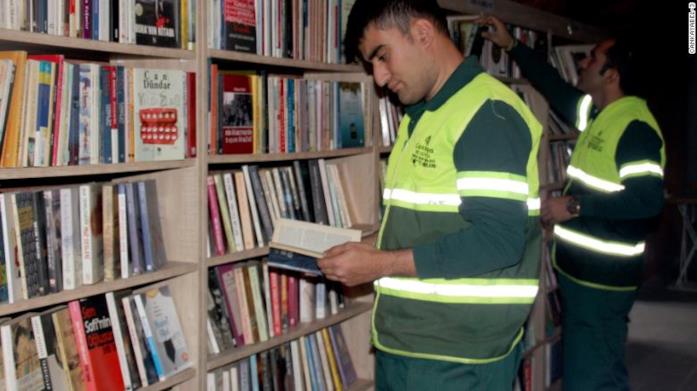 Netturbino nella biblioteca dei libri dimenticati di Ankara Primo piano di un netturbino mentre legge un libro nella biblioteca dei libri dimenticati di Ankara