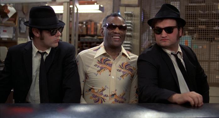 The Blues Brothers Una scena del film The Blues Brothers con i protagonisti seduti al pianoforte insieme a Ray Charles