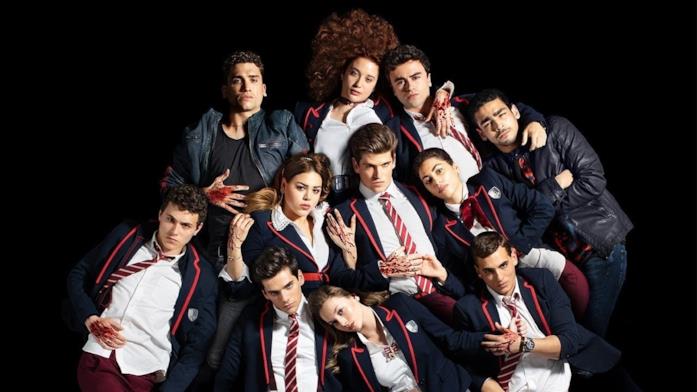 Il cast della serie televisiva Élite Alcuni personaggi di Élite si trovano distesi in un pavimento nero