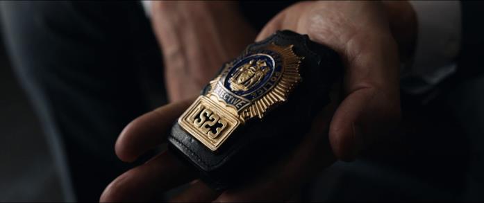 Michael mostra il distintivo da detective Michael mostra il distintivo da detective a Joanna