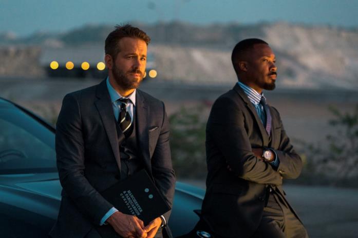 Ryan Reynolds e Corey Hawkins in una scena di 6 Underground Ryan Reynolds e Corey Hawkins appoggiati su un'auto al tramonto in una scena di 6 Underground