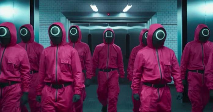 Squid Game: cosa succederà nella seconda stagione? Uomini con il volto coperto e la tuta rossa