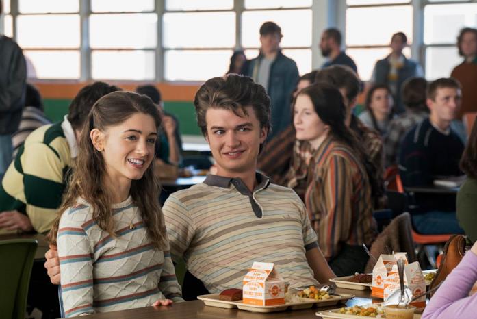 Steve e Nancy durante la loro relazione Steve e Nancy sorridenti e seduti a un tavolo nella mensa della scuola, con il vassoio del pranzo