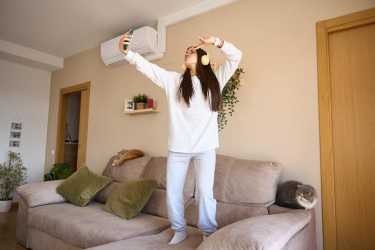 Ragazza si fa un selfie sul divano godendosi il fresco del climatizzatore