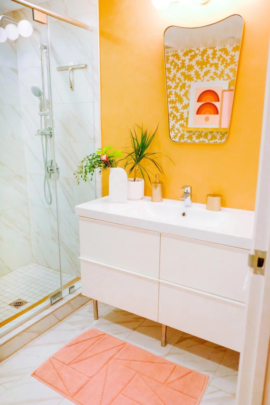 Bagno giallo con mobili bianchi