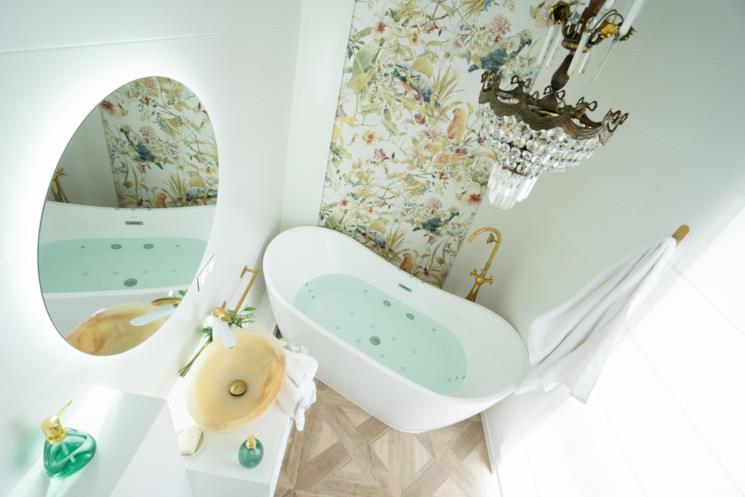 Bagno bianco con carta da parati decorata sul muro della vasca freestanding