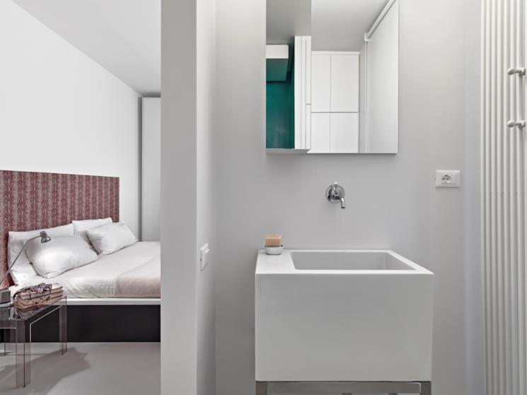 Bagno in camera con lavandino e specchio con credenza