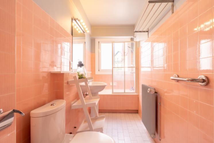 Bagno con piastrelle pesca e lavabo a colonna