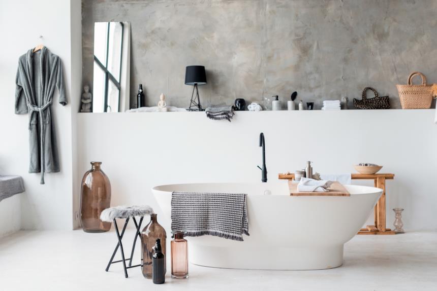 Bagno con vasca freestanding e pareti e pavimenti in microcemento bianco