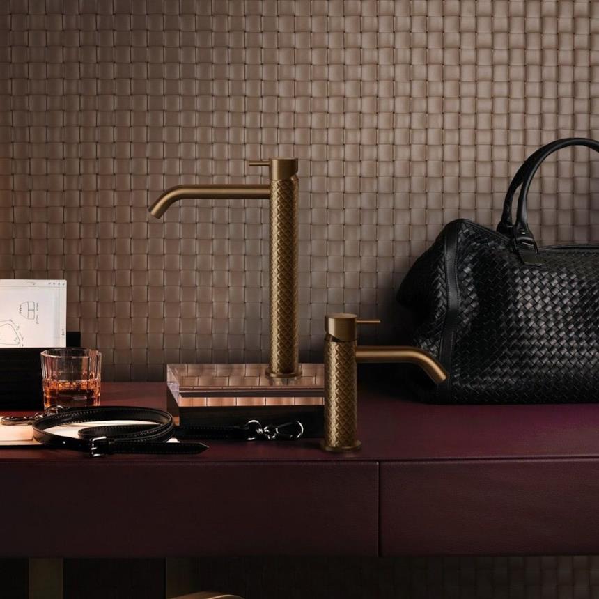 Gessi 316 rubinetto oro con borsa nera sul tavolo