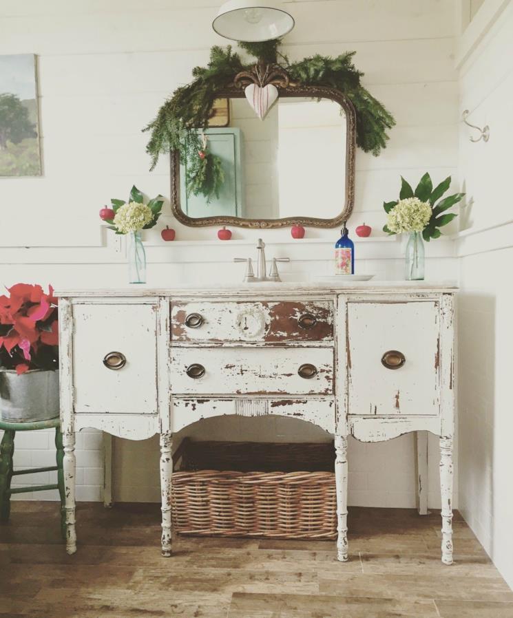 Bagno in stile arte povera con ramo di abete sullo specchio