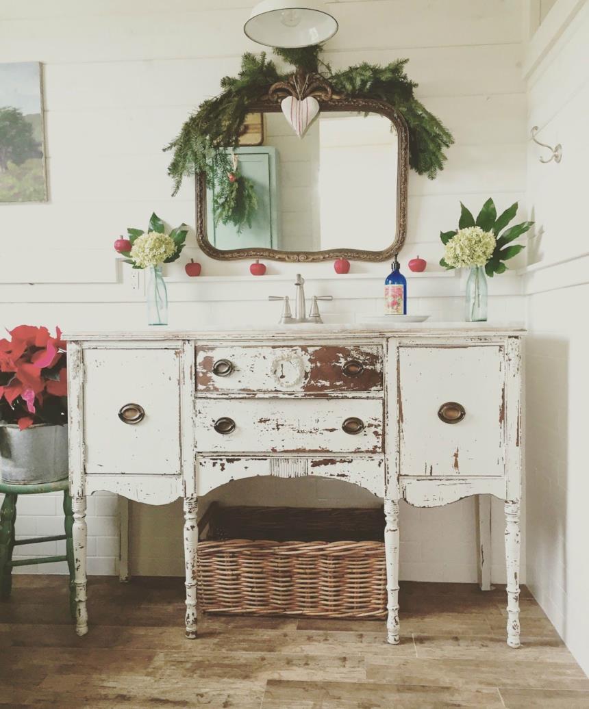 Bagno in stile arte povera con ramo di abete sullo specchio