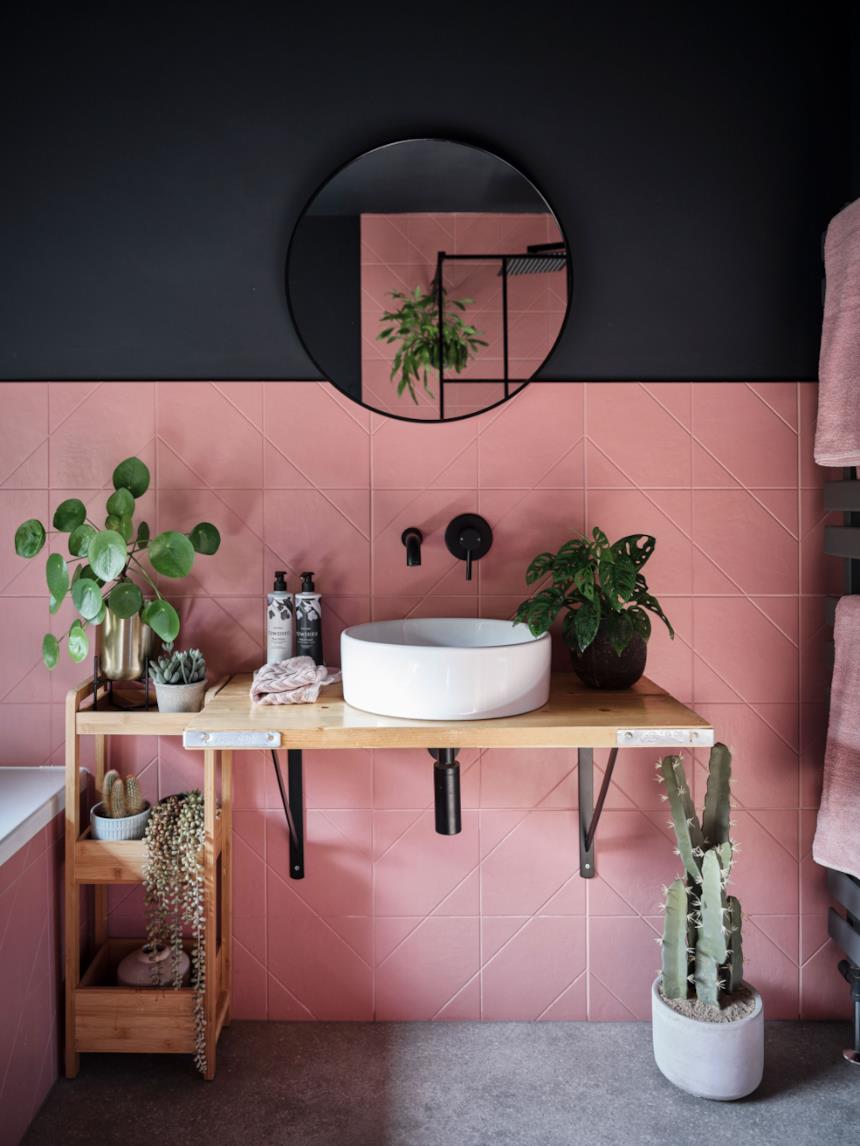 Bagno con piastrelle rosa e console lavabo in legno 