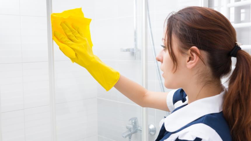 Donna pulisce il box doccia