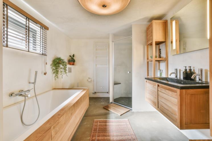Bagno con mobili in legno, vasca e doccia 