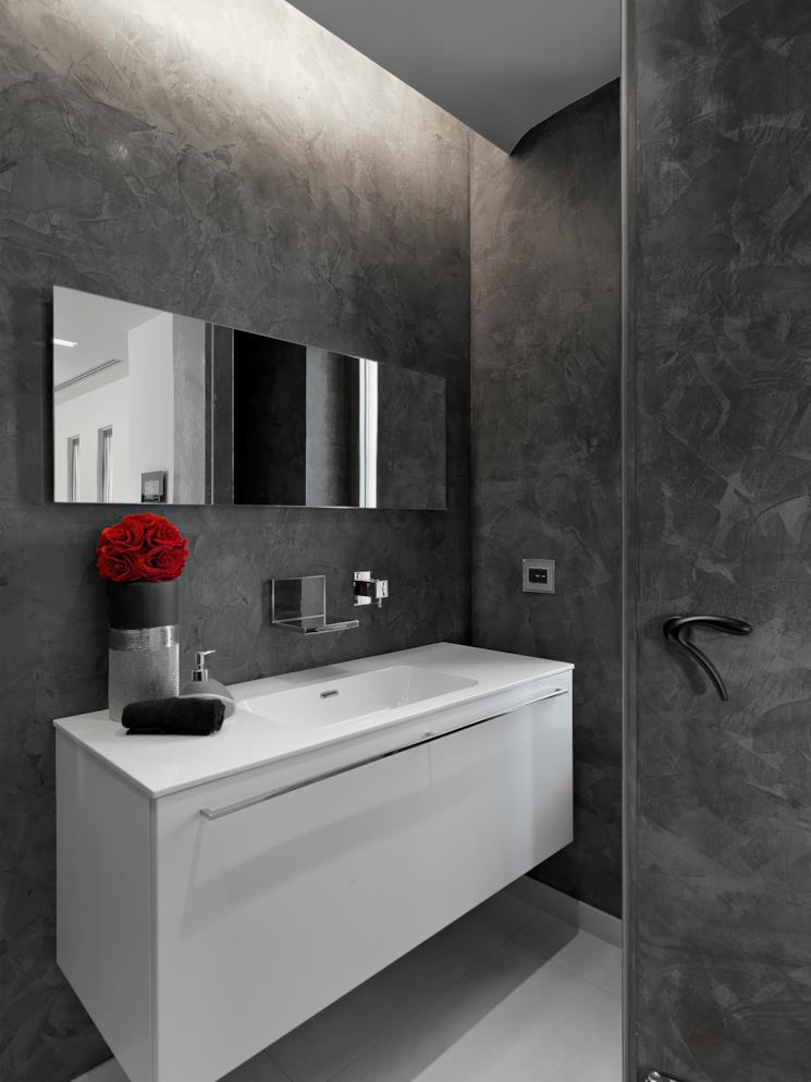 Bagno con pareti grigie e mobile portalavabo bianco