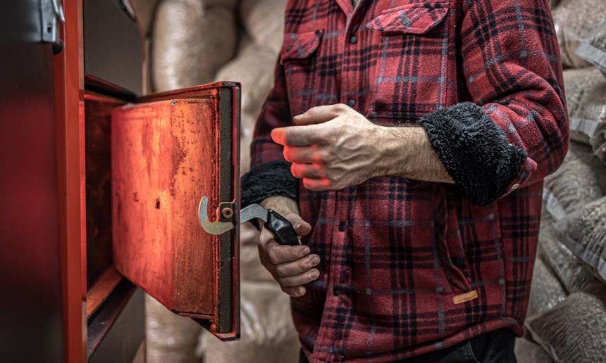 uomo che alimenta boiler a legna