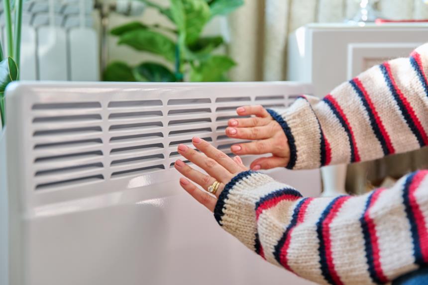 Persona si scalda le mani con un radiatore svedese 