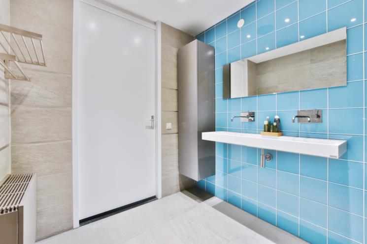 Bagno con parete a piastrelle azzurre