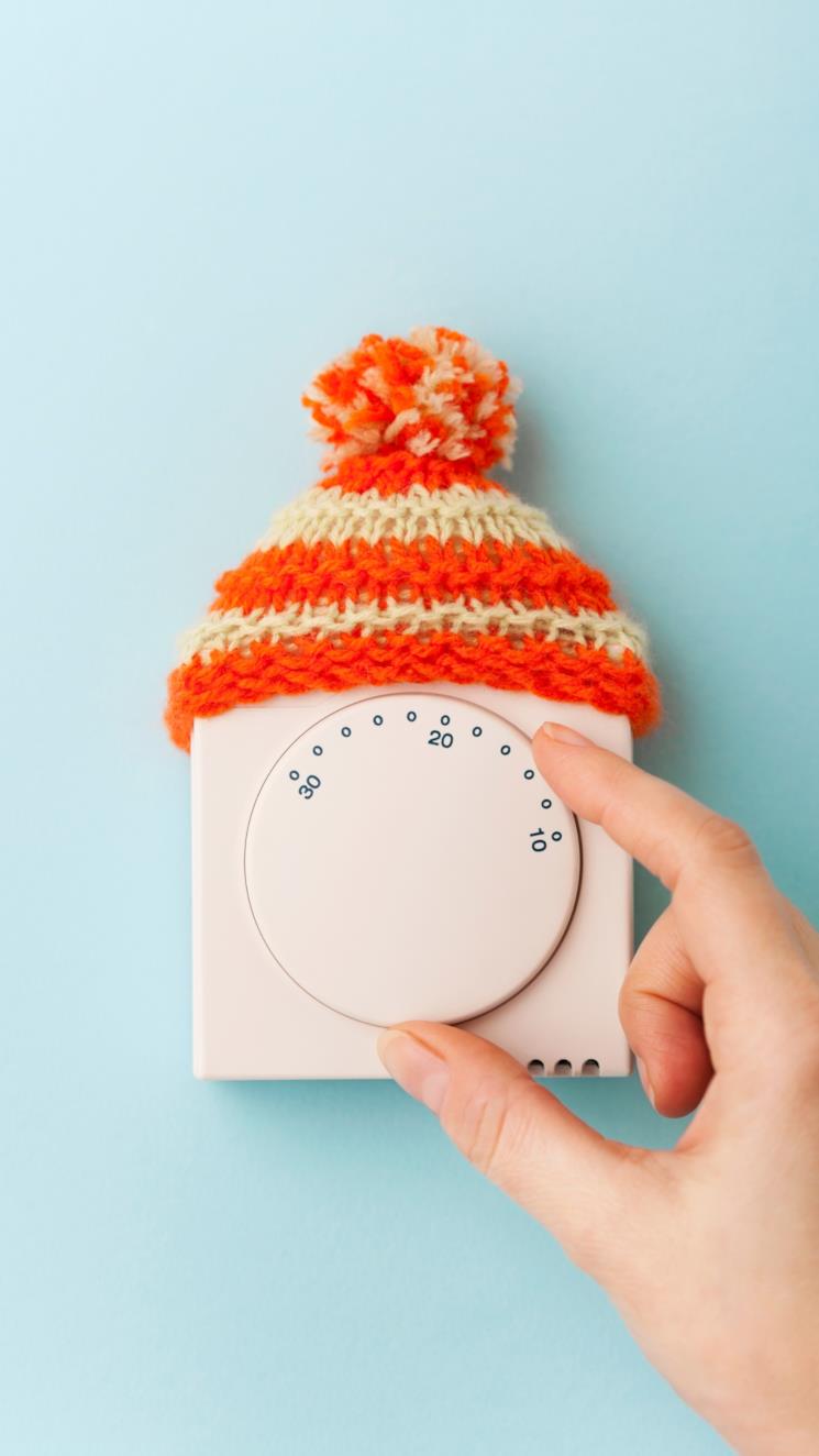 Mano che regola un termostato